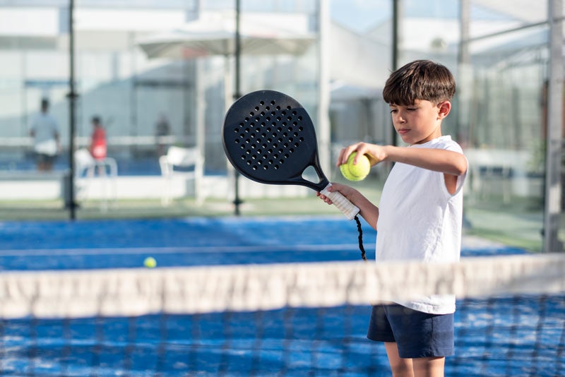 Young boy in white tshirt playing tennis