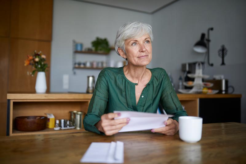 Mature woman in thought while sitting in kitchen