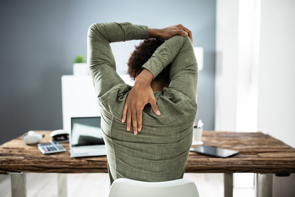 Woman stretching tricep at desk