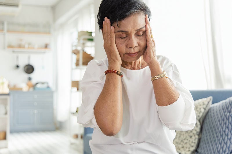 Older woman holding head and feeling stressed