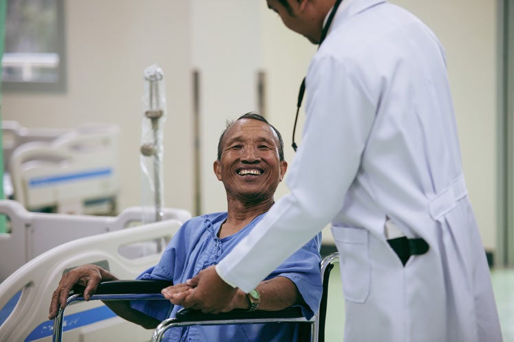 man in wheelchair with doctor in hospital