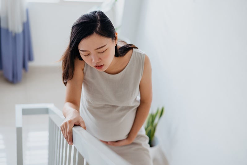 Tired pregnant woman climbing stairs