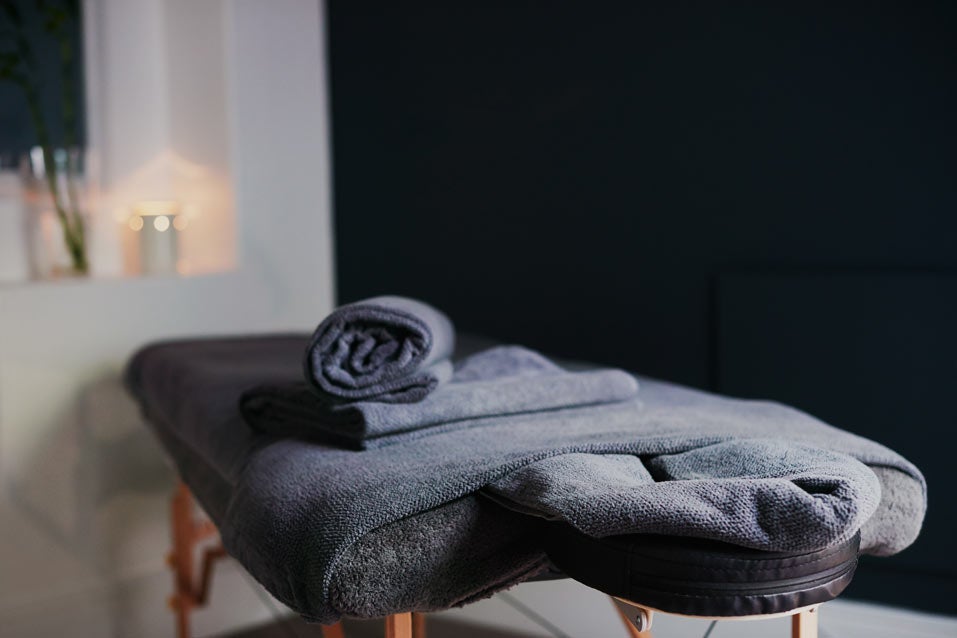 Massage bed with gray towels on it