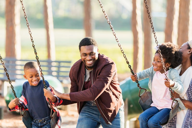 Family having fun on the swings