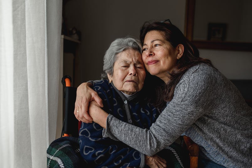 Portrait of woman in wheelchair hugging daughter with positive face